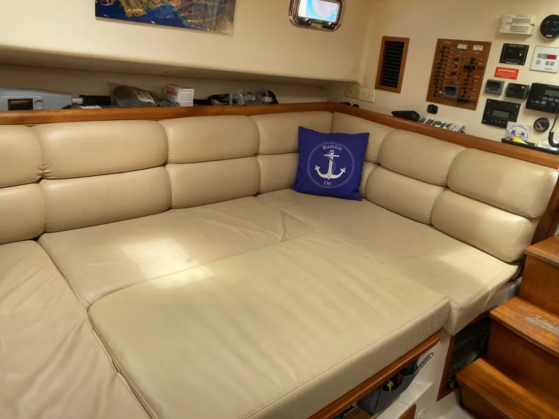 Slide: The Image of 2004 Mainship Pilot 34 interior with beige leather seating and nautical-themed decor. - 37