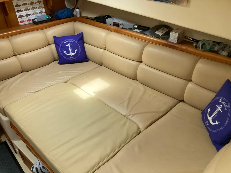 Slide: The Image of 2004 Mainship Pilot 34 interior with beige seating and nautical-themed pillows. - 38