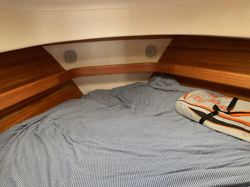 Slide: The Image of 2004 Mainship Pilot 34 cabin interior with striped bedding and wooden accents. - 41