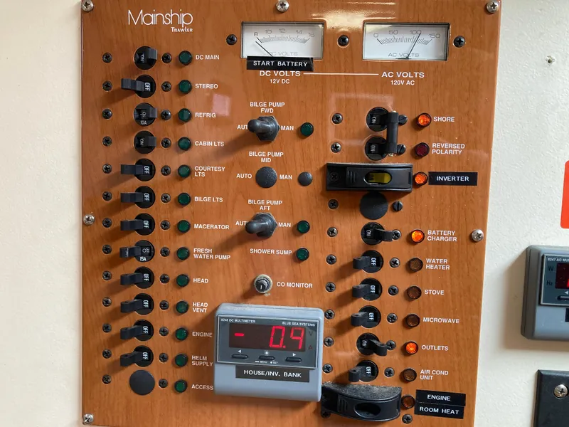 Slide: The Image of Electrical control panel of a 2004 Mainship Pilot 34 boat with various switches and gauges. - 44