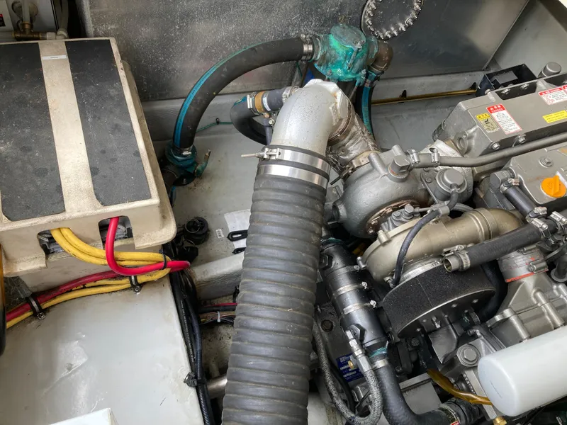 Slide: The Image of Engine compartment of a 2004 Mainship Pilot 34 boat, showing hoses and mechanical components. - 45