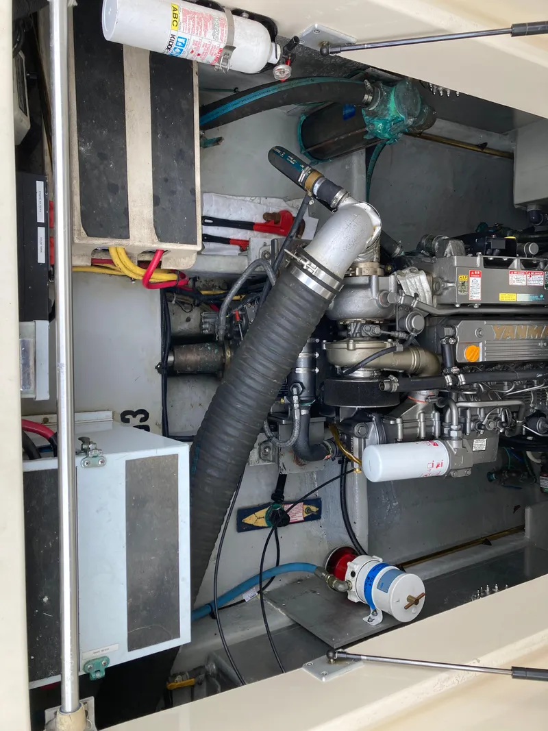 Slide: The Image of Engine compartment of a 2004 Mainship Pilot 34 boat, showcasing mechanical components and wiring. - 46