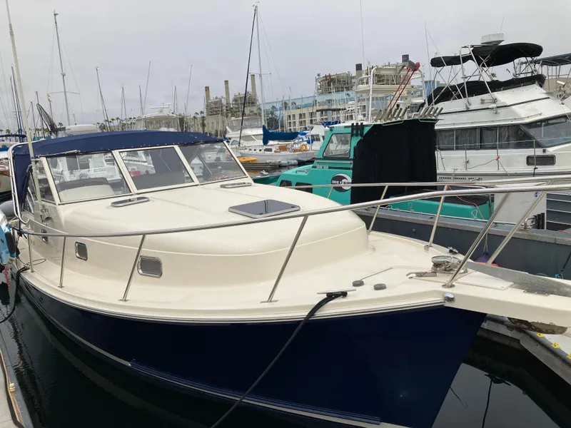 Slide: The Image of 2004 Mainship Pilot 34 docked in a marina, surrounded by other boats. - 5