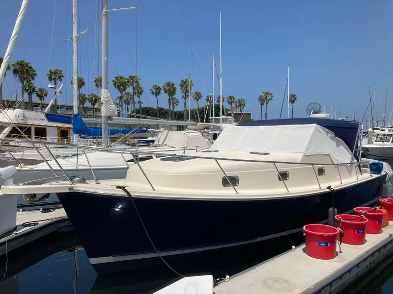 Slide: The Image of 2004 Mainship Pilot 34 docked at marina with palm trees in background. - 7