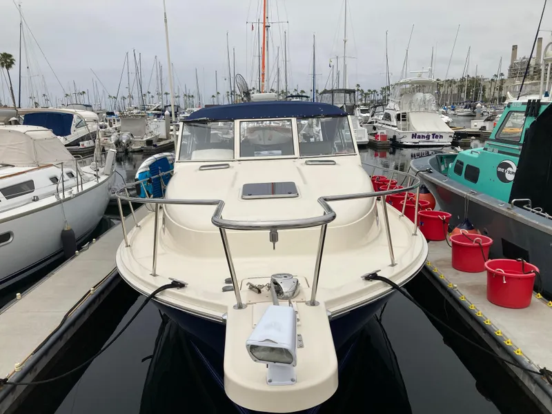 Slide: The Image of 2004 Mainship Pilot 34 docked at marina, surrounded by other boats. - 8