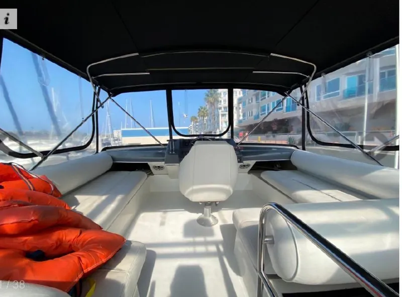 Slide: The Image of 1990 Bayliner 4387 Aft Cabin interior with seating, life jackets, and marina view. - 11