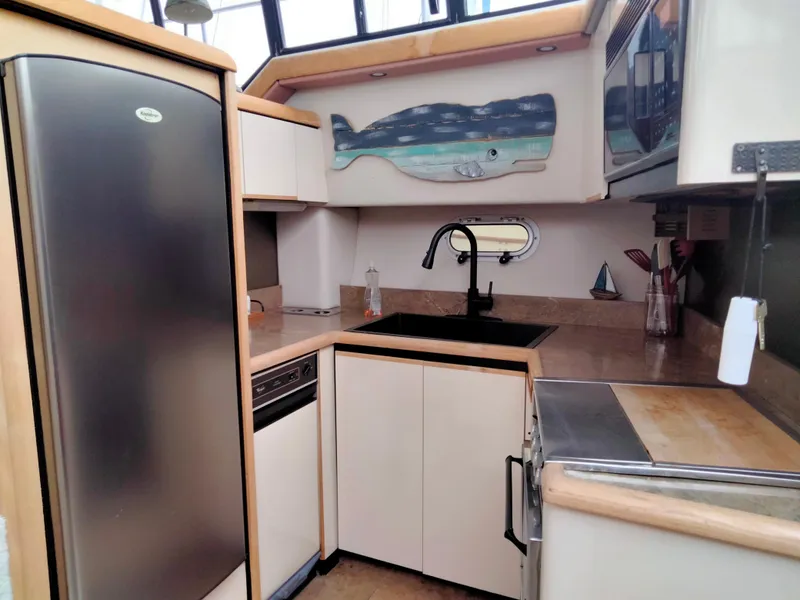 Slide: The Image of 1990 Bayliner 4387 Aft Cabin kitchen with modern appliances and whale wall art. - 14