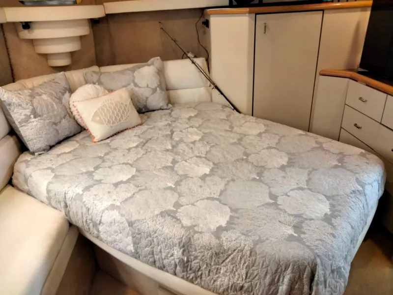 Slide: The Image of Cozy bedroom in 1990 Bayliner 4387 Aft Cabin with floral bedding and storage cabinets. - 24