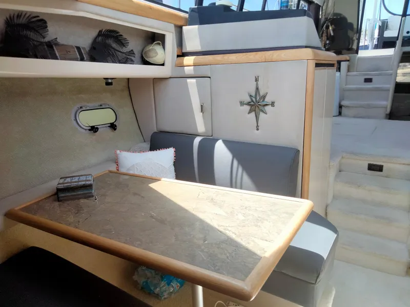 Slide: The Image of Interior of 1990 Bayliner 4387 Aft Cabin with dining area and nautical decor. - 9