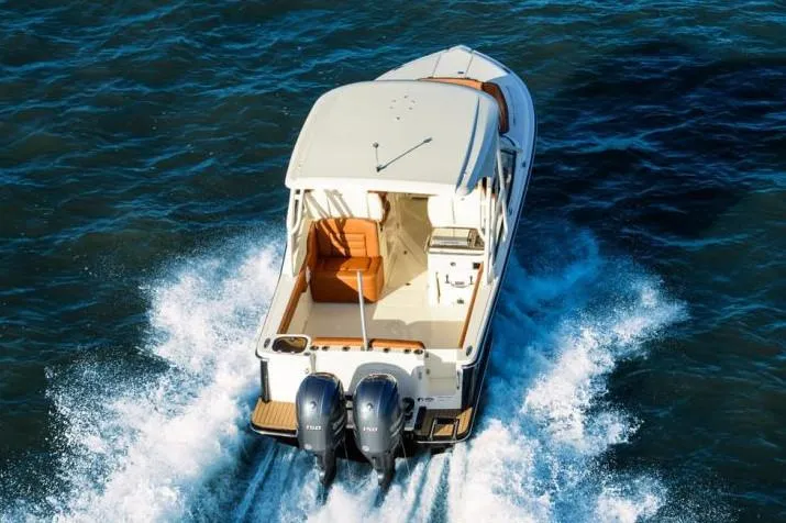 Slide: The Image of 2020 Scout 255 Dorado boat interior with seating and storage at a dock. - 2