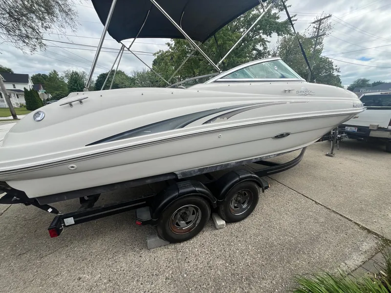 Slide: The Image of 2004 Sea Ray 220 Sundeck boat on trailer with canopy, parked on driveway. - 1