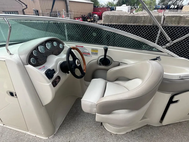 Slide: The Image of 2004 Sea Ray 220 Sundeck boat cockpit with steering wheel and control panel. - 18