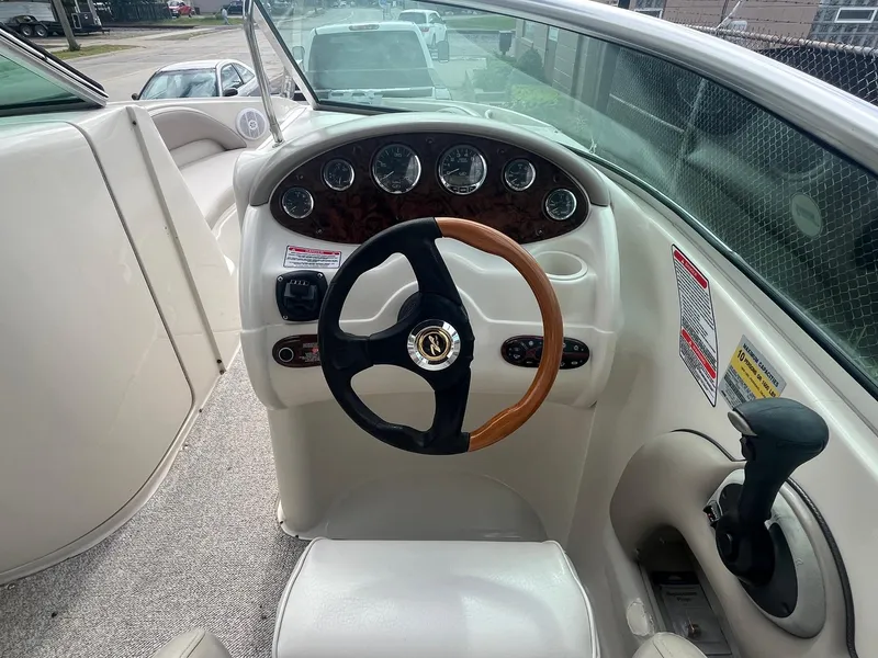 Slide: The Image of 2004 Sea Ray 220 Sundeck boat dashboard with steering wheel and control panel. - 19