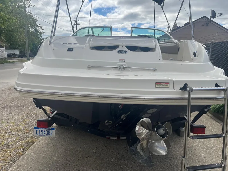 Slide: The Image of 2004 Sea Ray 220 Sundeck boat, rear view, on trailer, with ladder and propeller visible. - 2