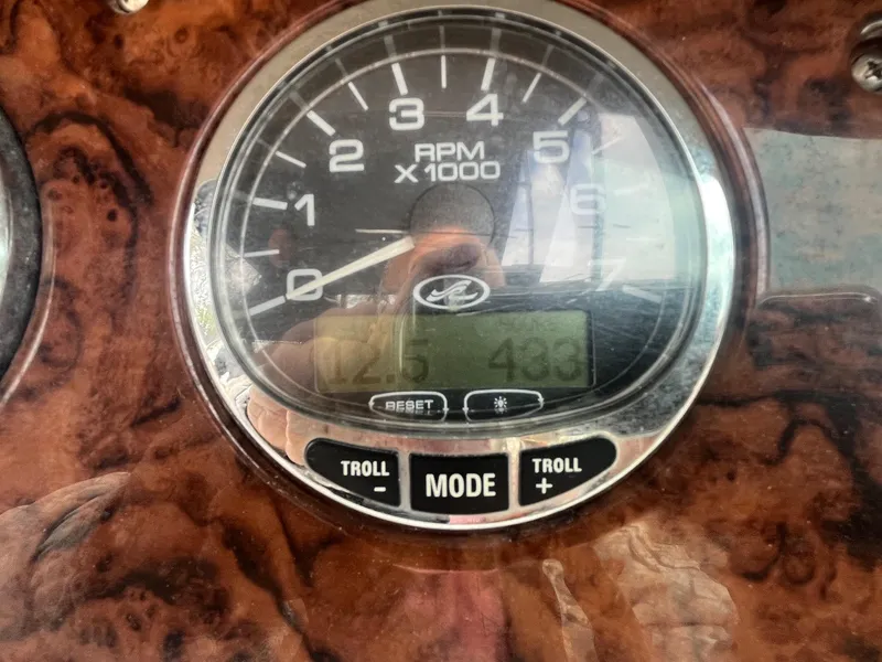 Slide: The Image of Close-up of a 2004 Sea Ray 220 Sundeck RPM gauge on a wooden dashboard. - 21