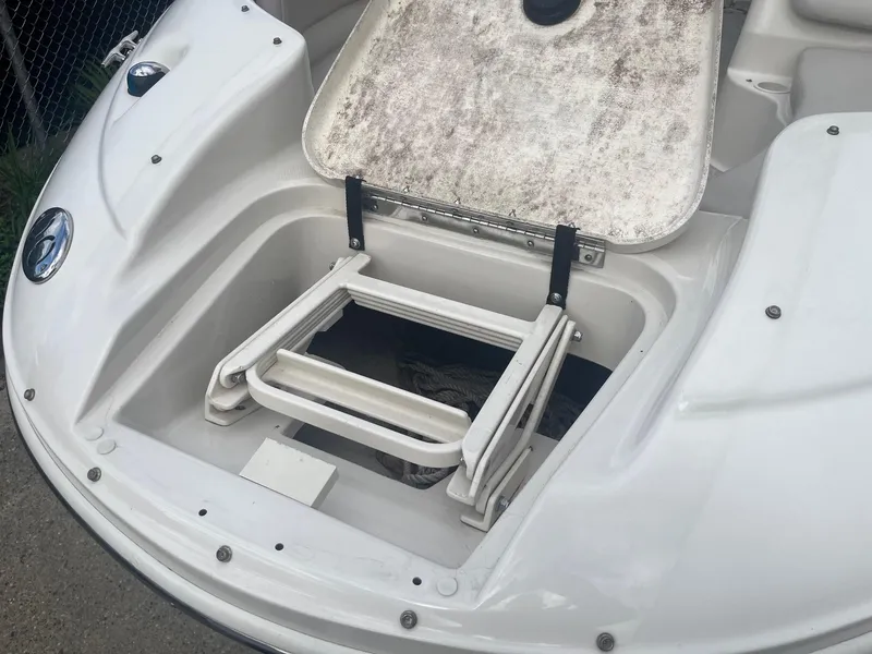 Slide: The Image of 2004 Sea Ray 220 Sundeck with open storage compartment and foldable ladder. - 4