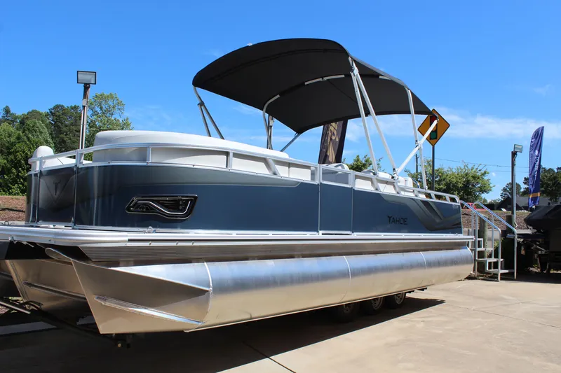 Slide: The Image of 2025 Tahoe Pontoon Sport 85 Versatile Rear Bench with canopy, docked under clear blue sky. - 2