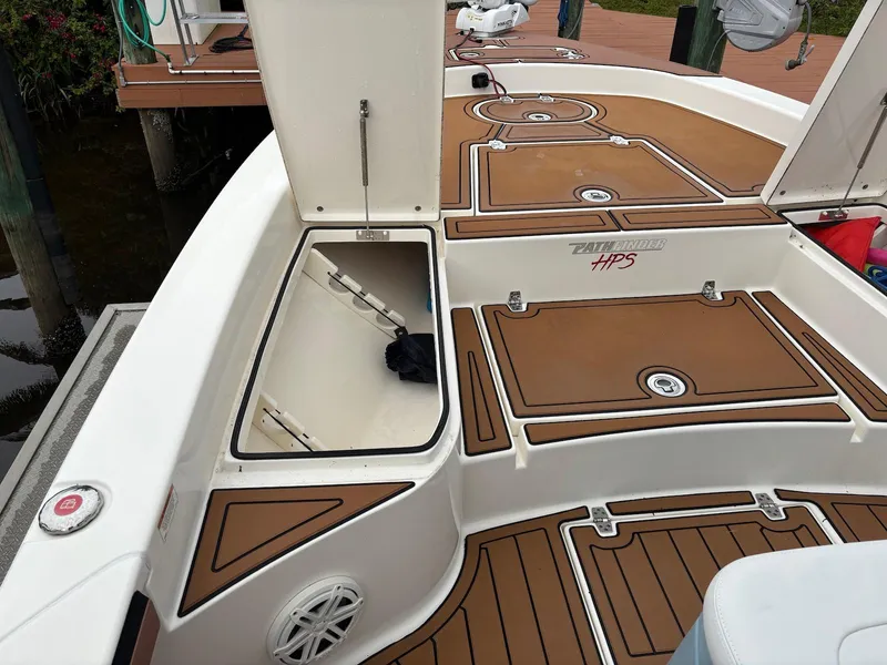 Slide: The Image of 2020 Pathfinder 2600 HPS boat deck with open storage compartments and brown flooring. - 10
