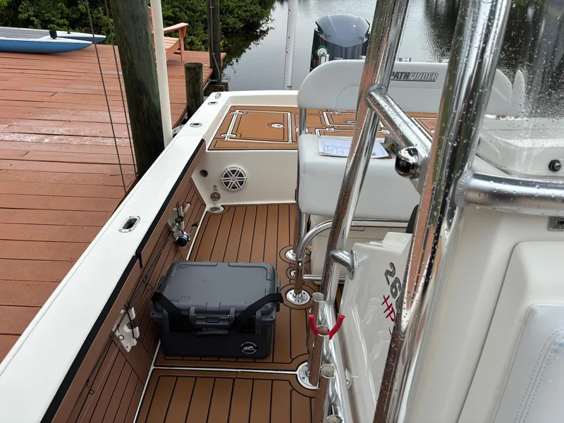 Slide: The Image of 2020 Pathfinder 2600 HPS boat interior with teak flooring and seating near a dock. - 19