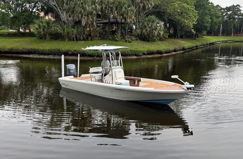Slide: The Image of 2020 Pathfinder 2600 HPS boat on a calm river with lush greenery. - 2