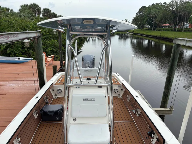 Slide: The Image of 2020 Pathfinder 2600 HPS boat docked by a serene river with lush greenery. - 21
