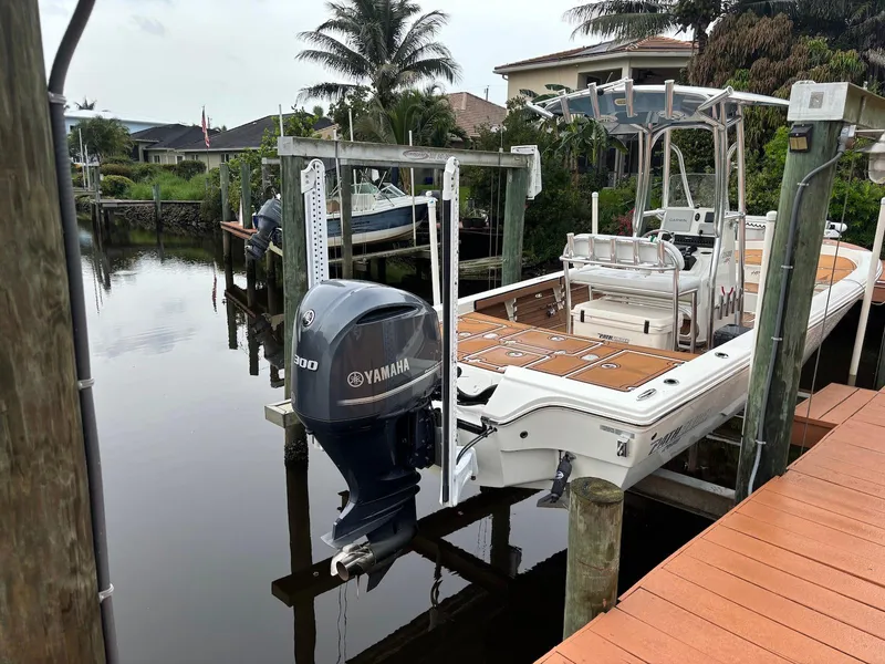 Slide: The Image of 2020 Pathfinder 2600 HPS boat docked with Yamaha engine, surrounded by waterfront homes and palm trees. - 3