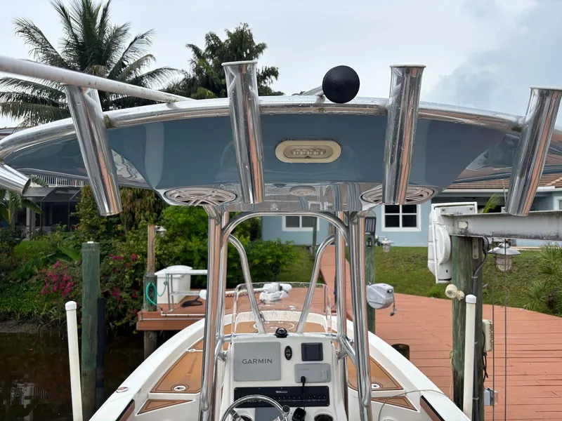 Slide: The Image of 2020 Pathfinder 2600 HPS boat with T-top and fishing rod holders, docked near palm trees. - 6