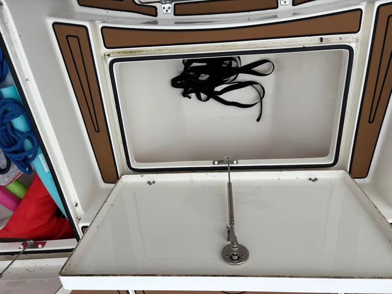 Slide: The Image of Open storage compartment on a 2020 Pathfinder 2600 HPS boat, showing ropes and accessories. - 8