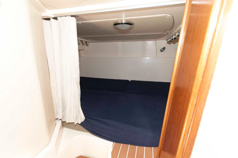 Slide: The Image of 2006 Grady-White Express 360 cabin interior with blue bedding and wooden accents. - 24