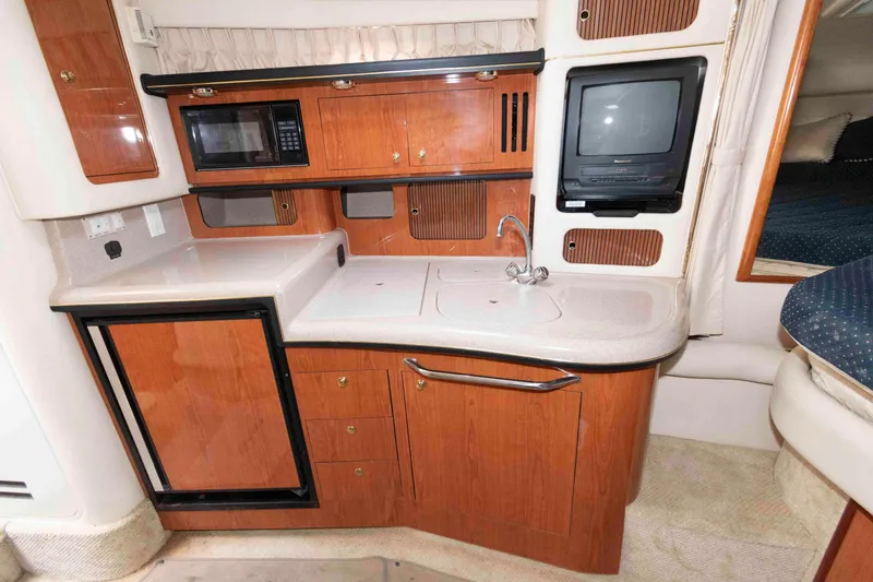 Slide: The Image of 2001 Sea Ray 340 Sundancer interior kitchen with wood cabinets, sink, and appliances. - 10
