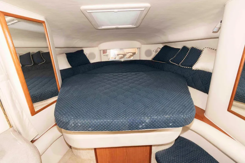 Slide: The Image of 2001 Sea Ray 340 Sundancer cabin with blue bedding and mirrors. - 11
