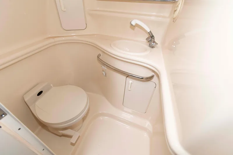 Slide: The Image of 2001 Sea Ray 340 Sundancer bathroom with toilet, sink, and storage compartments. - 13
