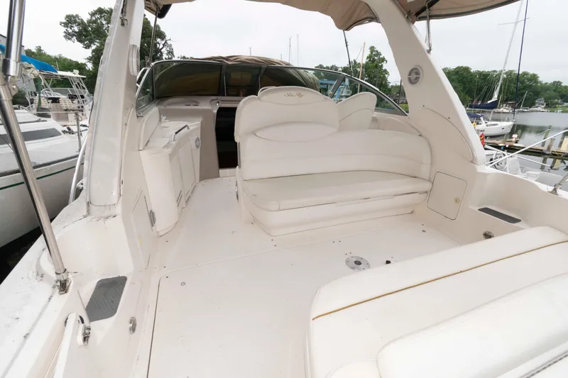 Slide: The Image of 2001 Sea Ray 340 Sundancer boat interior with white seating and helm, docked at marina. - 3