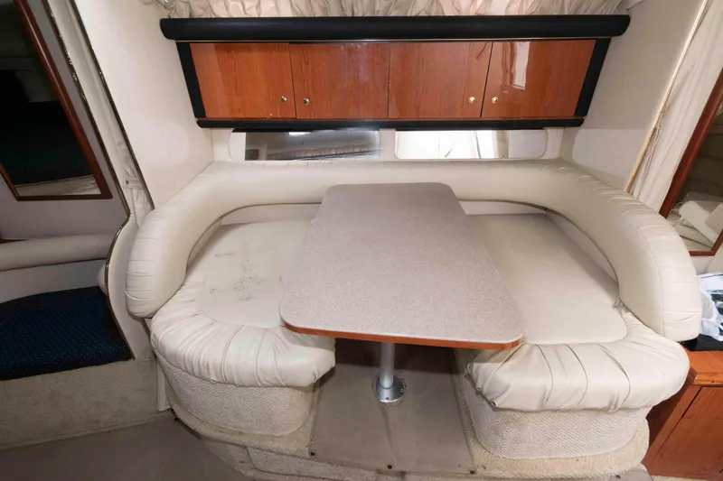 Slide: The Image of Interior of 2001 Sea Ray 340 Sundancer with beige seating and wooden cabinets. - 9