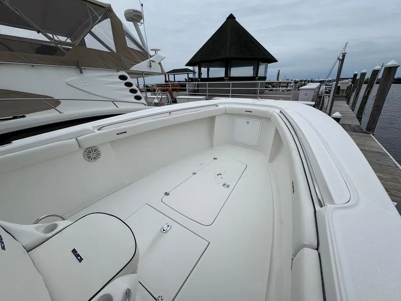 Slide: The Image of 2004 Wellcraft Scarab Fisherman CCF 35 boat docked, showcasing spacious white deck and seating area. - 17