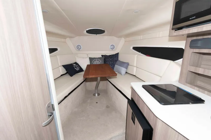 Slide: The Image of 2019 Regal 26 XO cabin interior with seating, table, and modern amenities. - 11