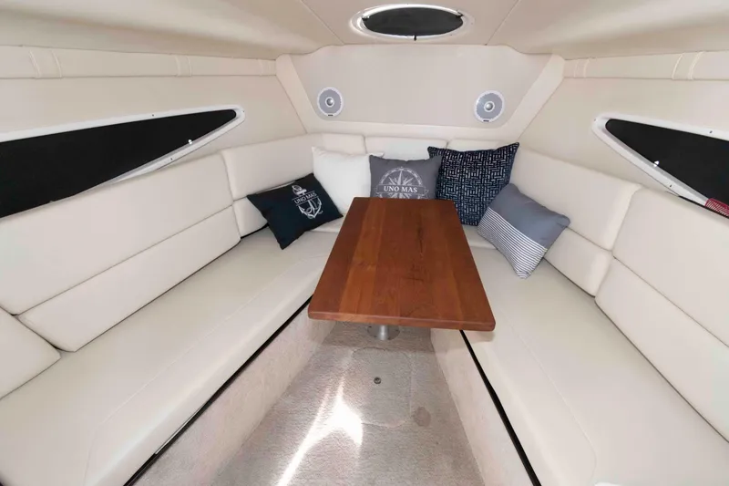 Slide: The Image of 2019 Regal 26 XO cabin interior with beige seating and wooden table. - 12