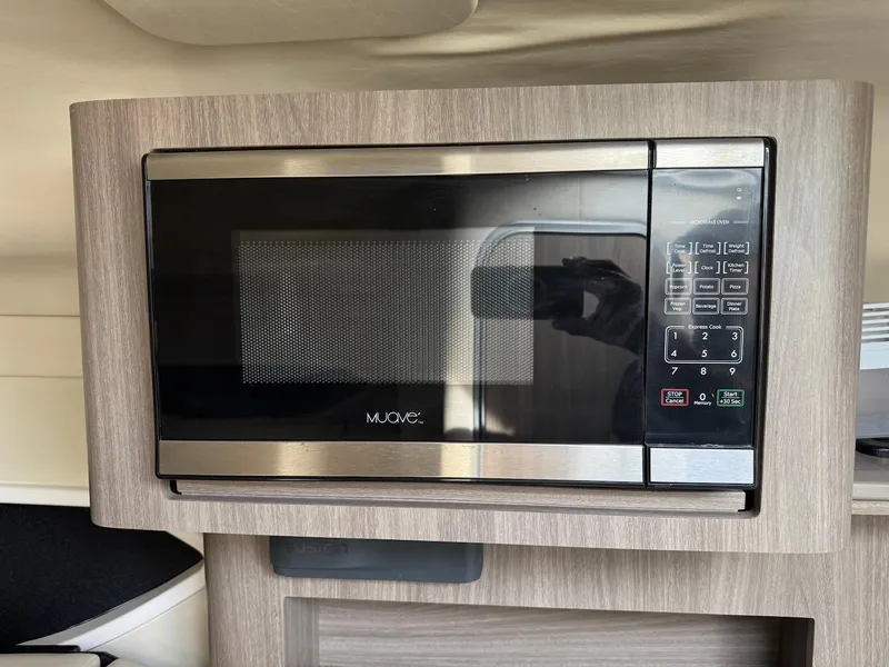 Slide: The Image of Microwave in 2019 Regal 26 XO boat interior, featuring sleek wood paneling. - 15