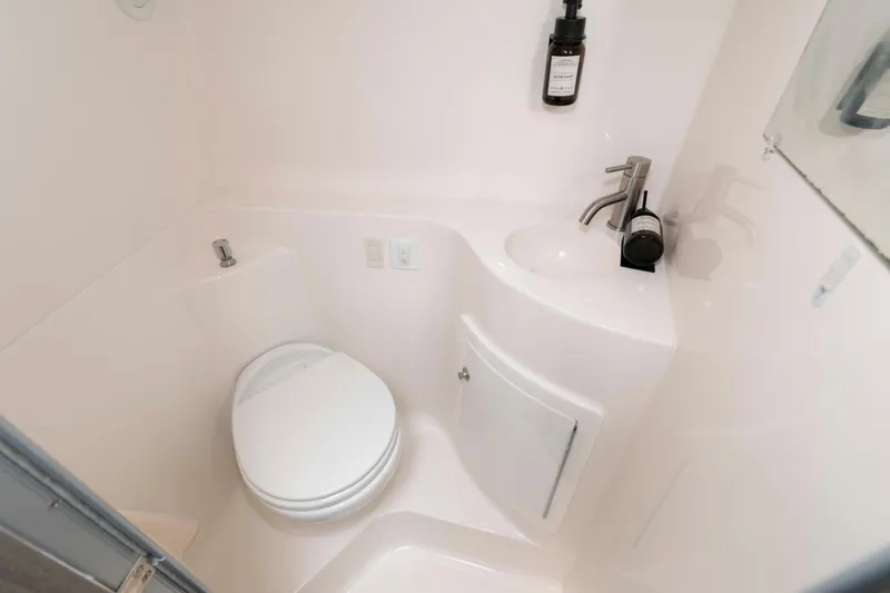 Slide: The Image of Compact bathroom in a 2019 Regal 26 XO boat, featuring a toilet and sink. - 18