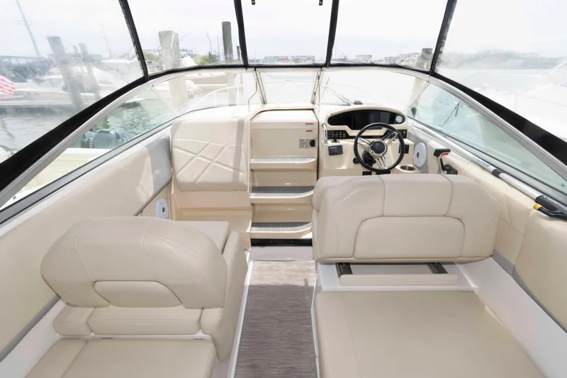 Slide: The Image of 2019 Regal 26 XO boat interior with beige seating and modern dashboard. - 4