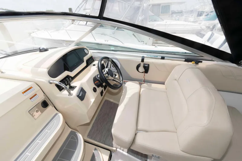 Slide: The Image of 2019 Regal 26 XO boat interior with steering wheel and beige seating. - 5