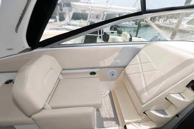 Slide: The Image of 2019 Regal 26 XO boat interior with beige seating and waterfront view. - 7