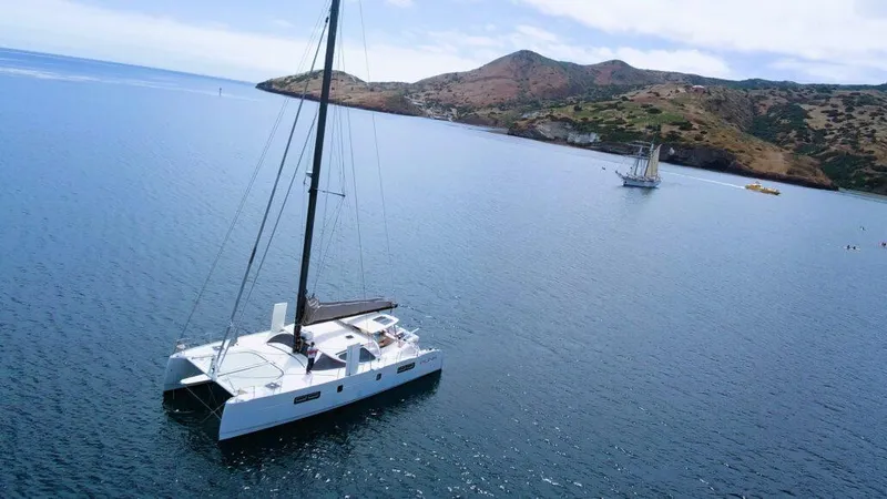 Slide: The Image of 2011 Performance Catamarans 52 sailing near scenic coastline and mountains. - 12