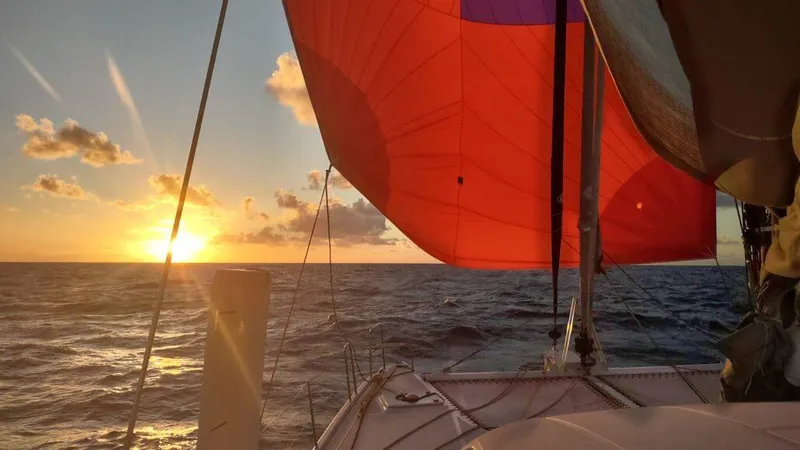 Slide: The Image of Sailing catamaran at sunset, Performance Catamarans 52, 2011 model, with vibrant red sail. - 22