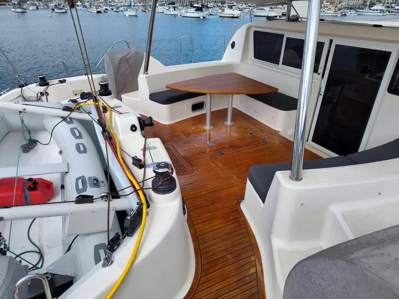 Slide: The Image of 2011 Performance Catamarans 52 with wooden deck, seating area, and inflatable boat in marina. - 29