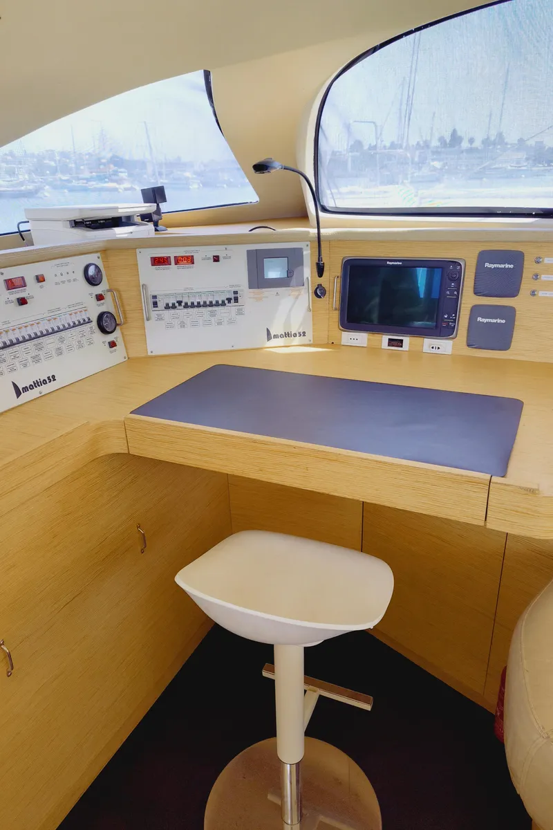 Slide: The Image of Navigation station inside 2011 Performance Catamarans 52, featuring control panels and a swivel chair. - 46