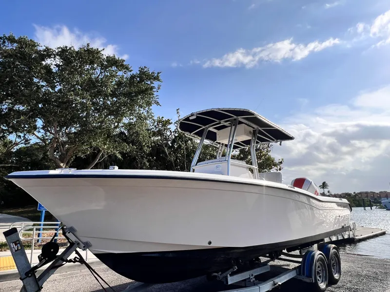Slide: The Image of 2003 Grady-White Advance 257 boat on trailer, parked near water under blue sky. - 5