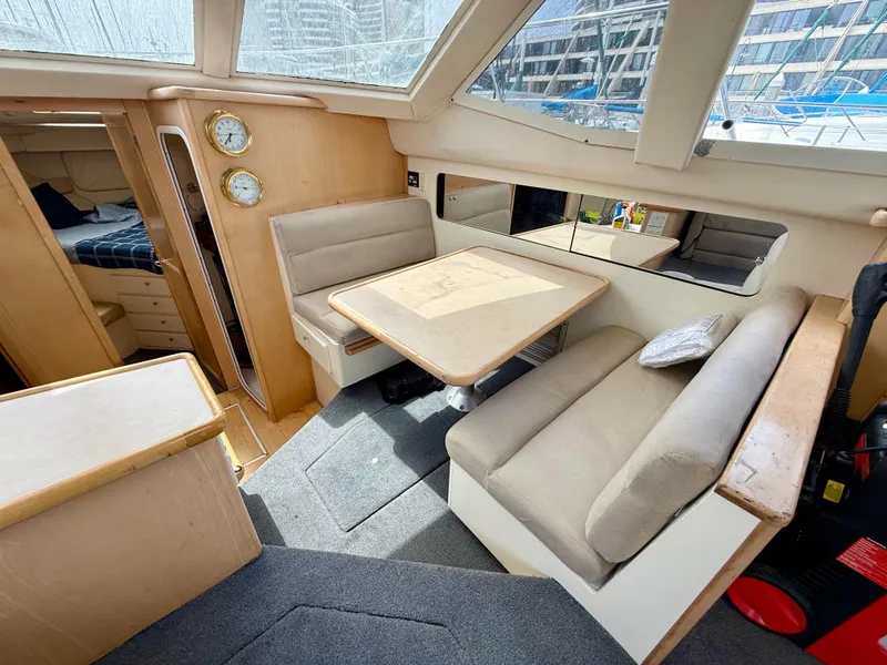 Slide: The Image of 1997 Carver 355 Aft Cabin interior with dining area and beige seating. - 12