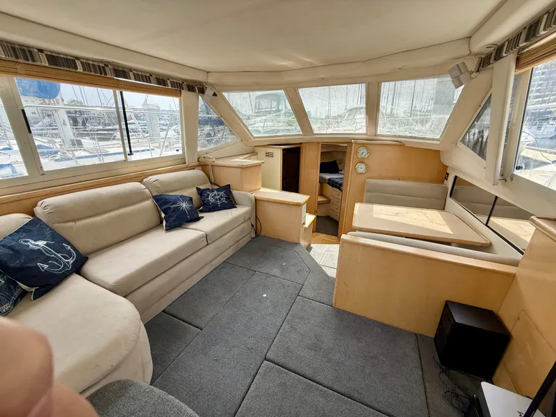 Slide: The Image of Interior of 1997 Carver 355 Aft Cabin yacht with beige seating and nautical decor. - 13