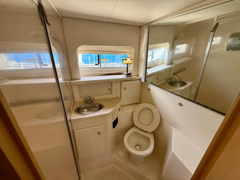 Slide: The Image of 1997 Carver 355 Aft Cabin bathroom with sink, toilet, and mirror. - 15